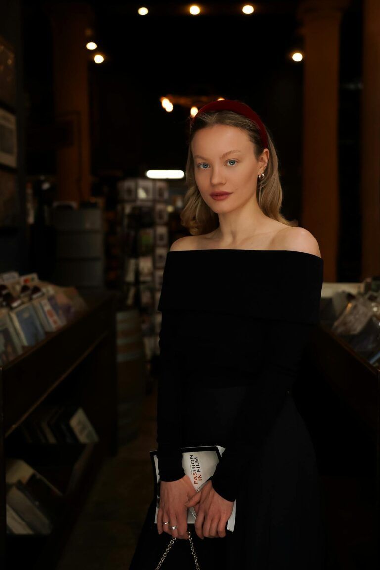 A woman in a black off the shoulder top and skirt